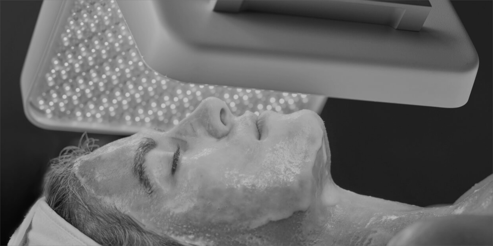 A man with his eyes closed is getting a facial
